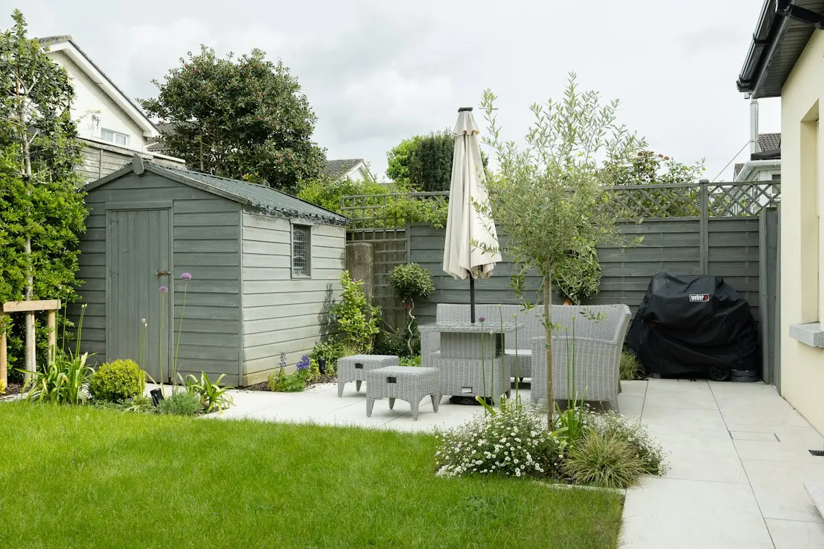 Backyard paver patio with outdoor seating, lawn and a slatted privacy fence